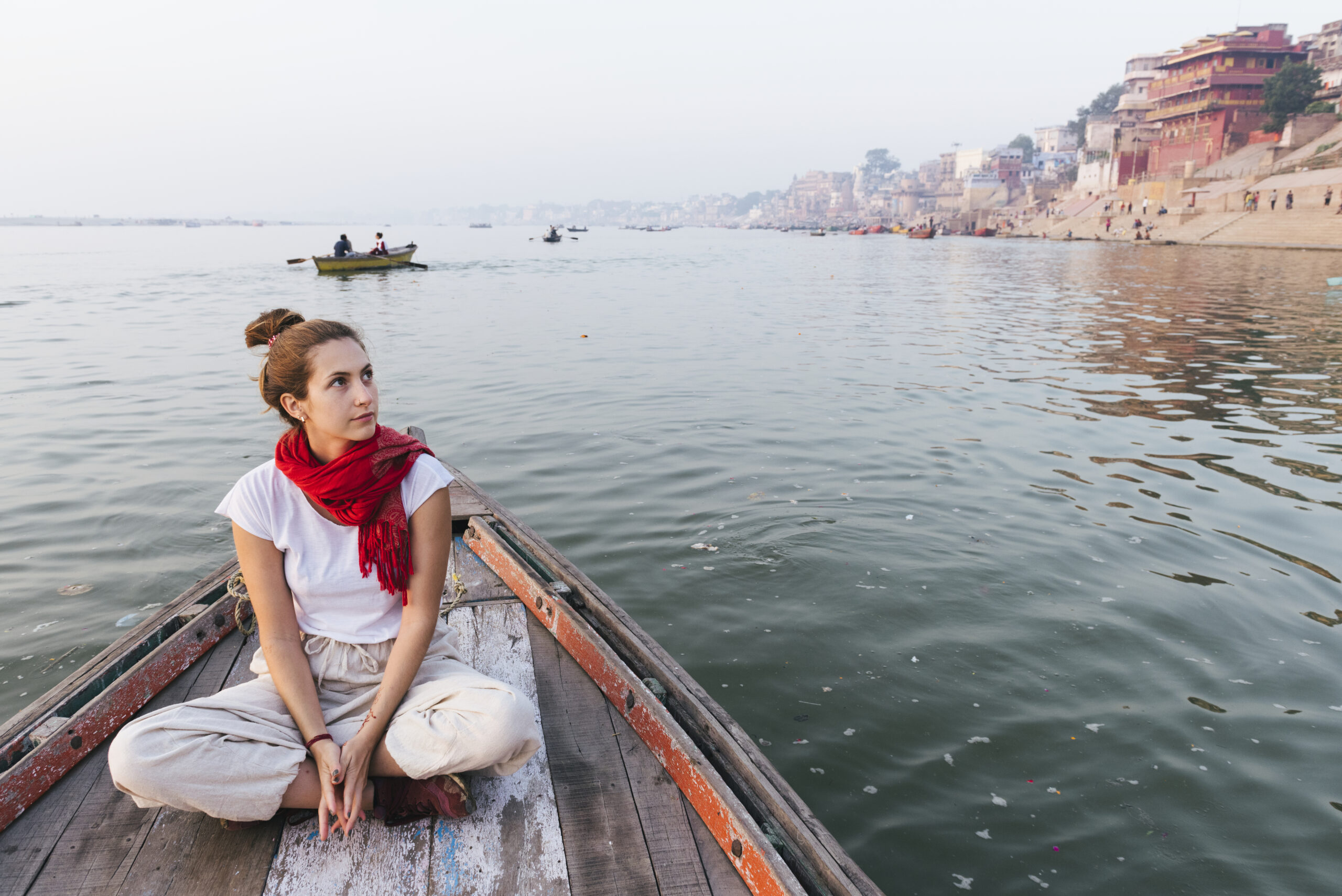 Western woman on a boat exploring the River Ganges